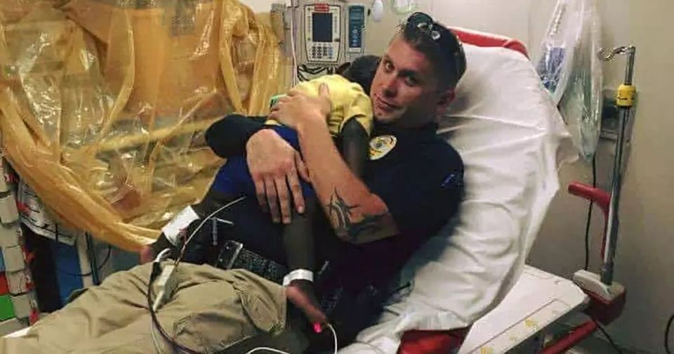 A picture of a cop curling up with an abandoned toddler has become viral – look closely and you’ll understand why